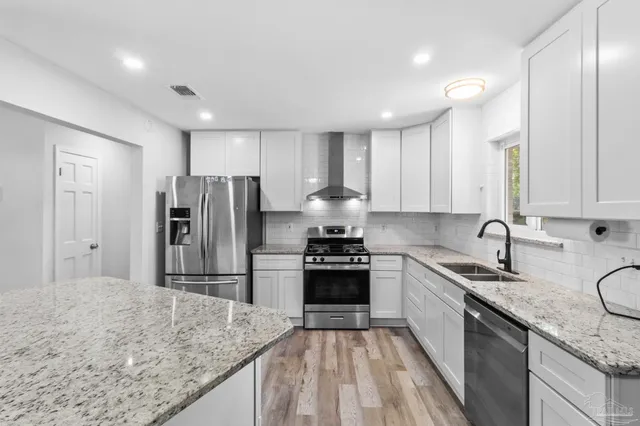 a kitchen with stainless steel appliances a refrigerator stove and sink