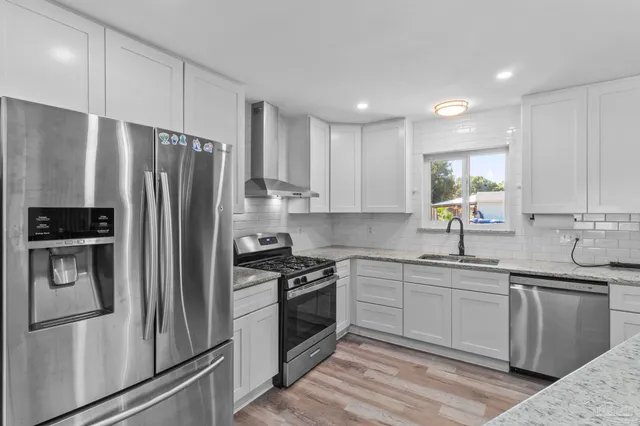 a kitchen with stainless steel appliances granite countertop a refrigerator and a stove