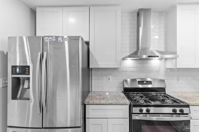 a kitchen with stainless steel appliances granite countertop a sink stove and cabinets