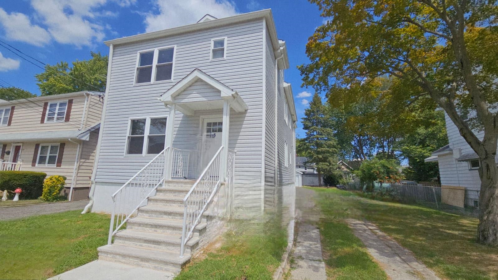 125 Birch Street, Unit 2 Bloomfield, NJ 07003 - Photo 2 of 11 a view of a white house next to a yard with big trees