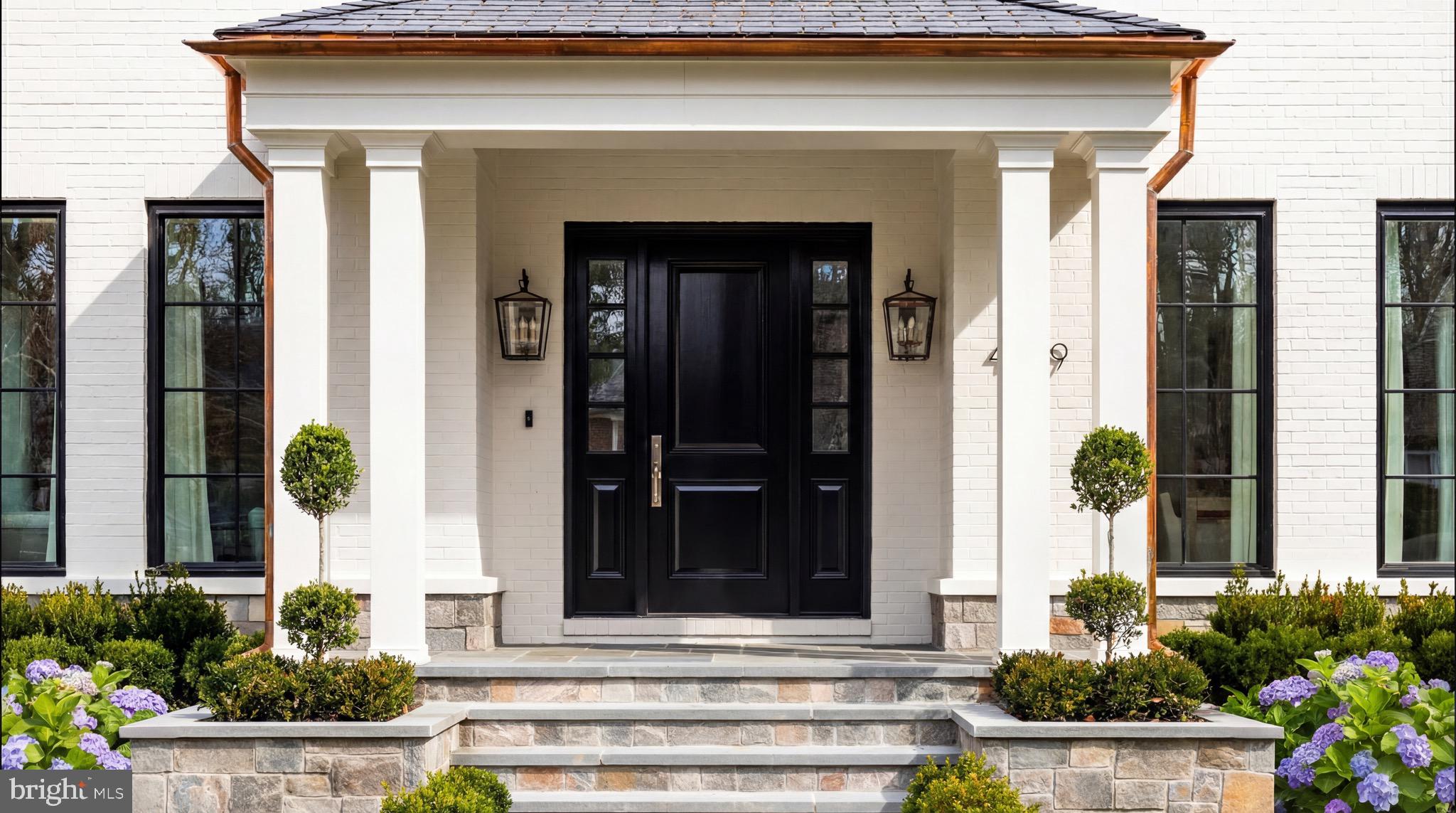 4939 Quebec Street Northwest Washington, DC 20016 - Photo 3 of 50 a front view of a house with potted plants
