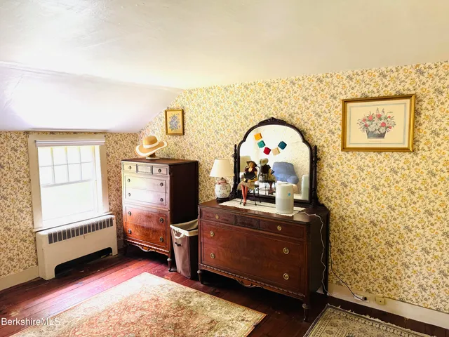a kitchen with a stove a counter space a sink and living room view