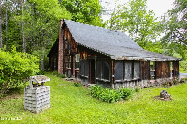 a view of an house with backyard and a tree