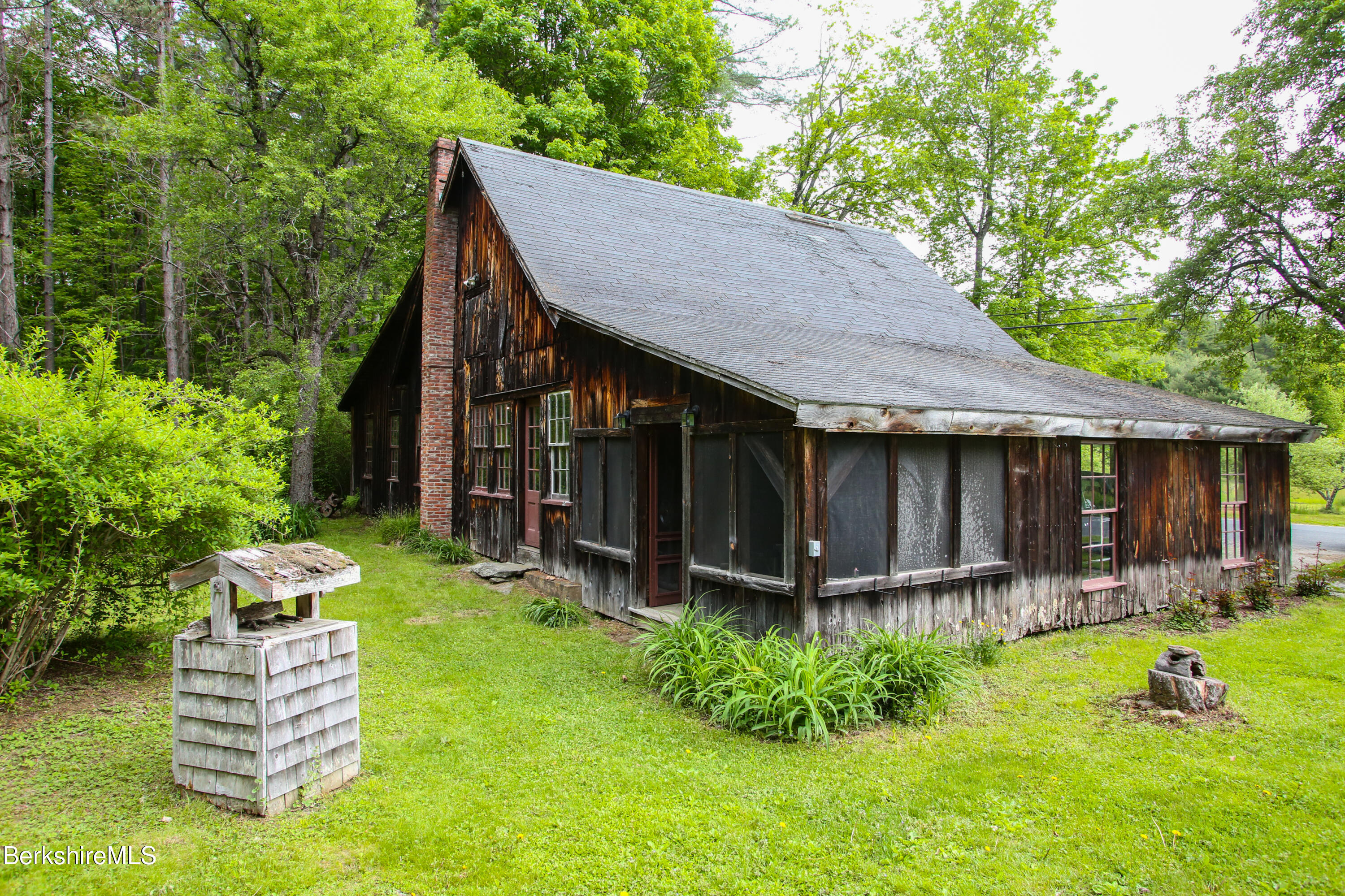 31 West Oxbow Road Charlemont, MA 01370 - Photo 31 of 39 a backyard of a house with garden and outdoor seating