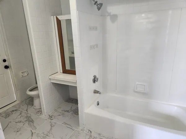 a bathroom with a bathtub a toilet and a shower