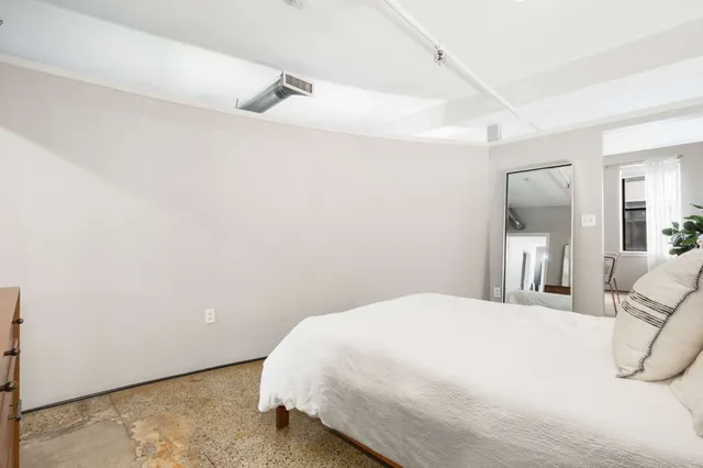 a bedroom with a bed and a mirror