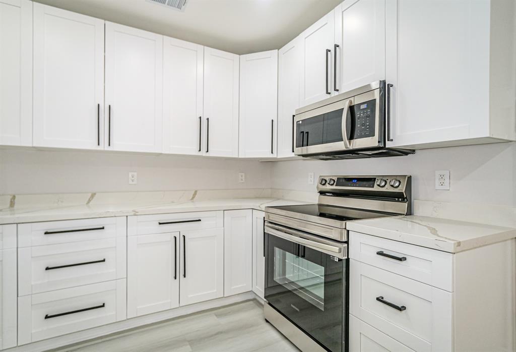 22808 Southwest 89th Path Cutler Bay, FL 33190 - Photo 11 of 35 a kitchen with white cabinets stainless steel appliances and sink