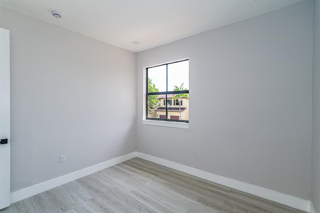 22808 Southwest 89th Path Cutler Bay, FL 33190 - Photo 25 of 35 a view of an empty room with wooden floor and a window
