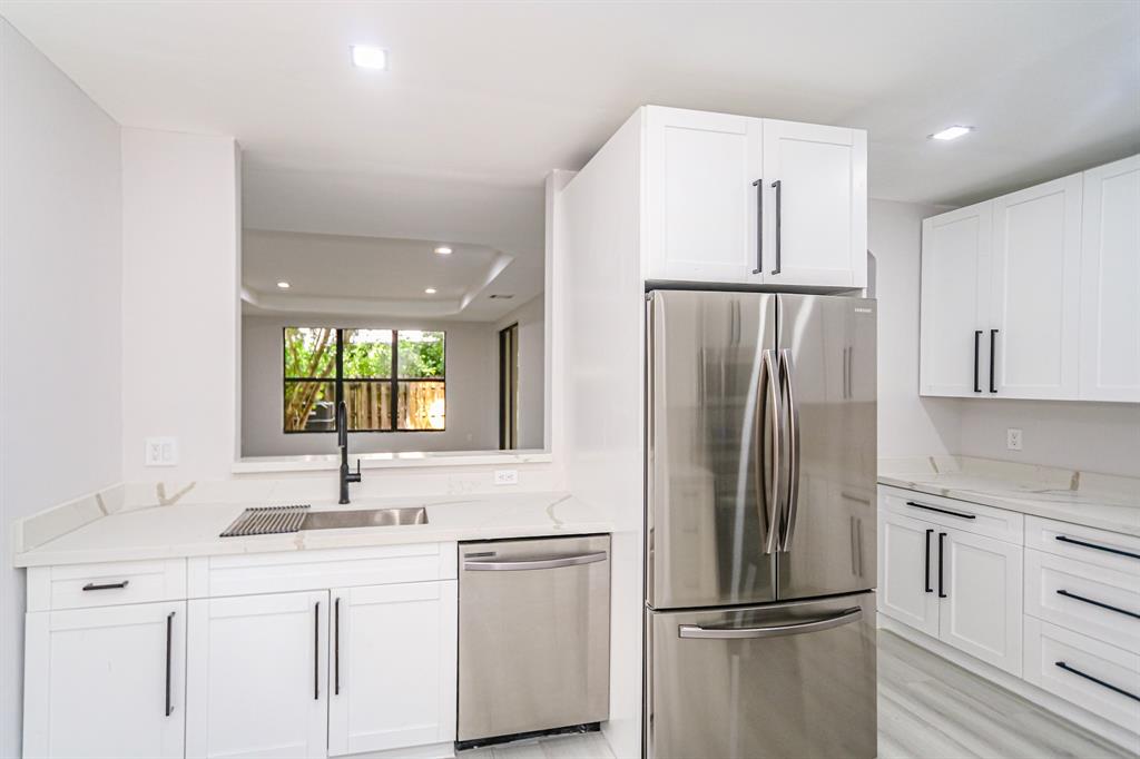 22808 Southwest 89th Path Cutler Bay, FL 33190 - Photo 9 of 35 a kitchen with white cabinets and stainless steel appliances