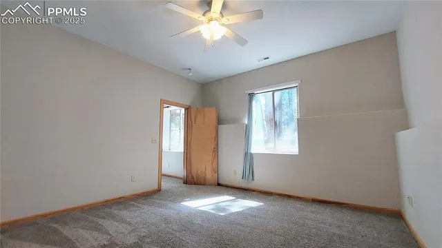a view of an empty room with window and cabinet