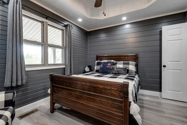 a spacious bedroom with a bed and a chandelier