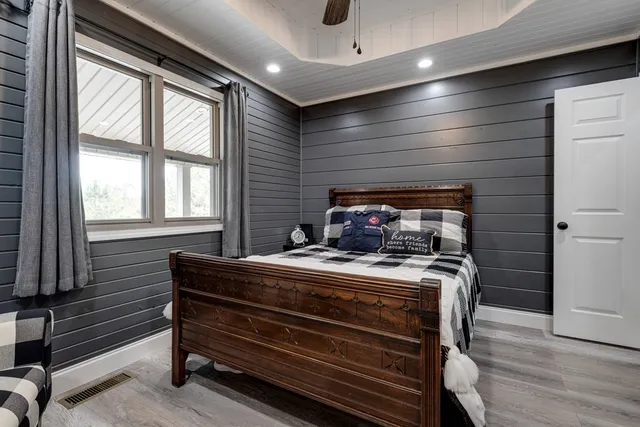 a spacious bedroom with a bed and a chandelier