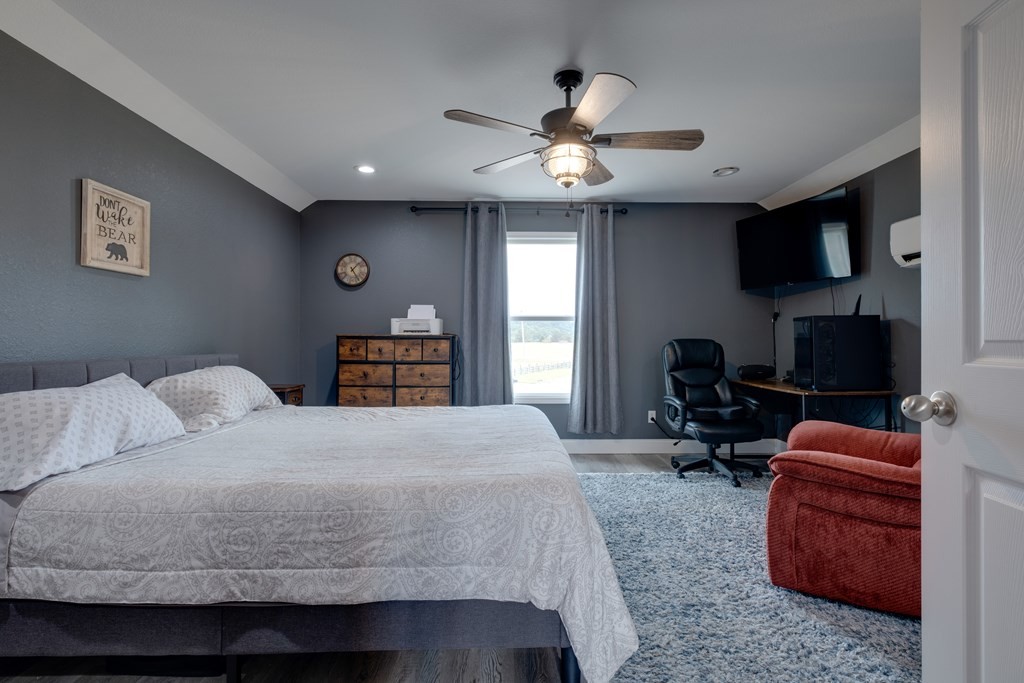4700 Honey Creek Loop Road Allardt, TN 38504 - Photo 61 of 70 a bedroom with a bed a couch and a chandelier