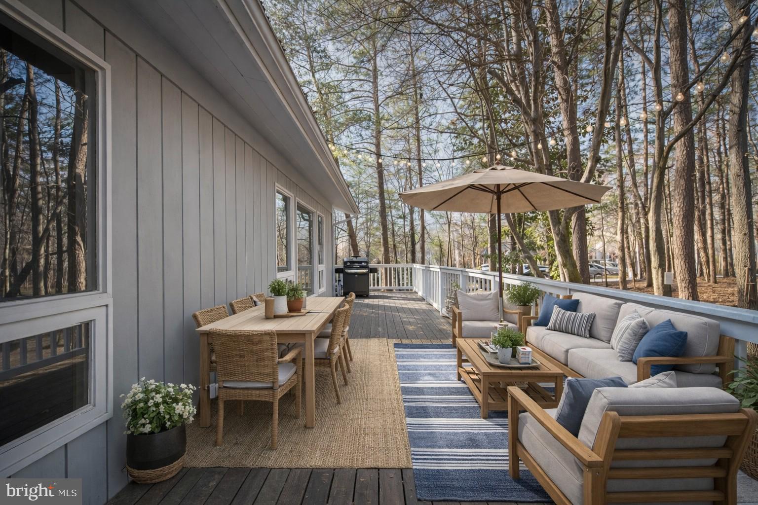 28 Tanglewood Road Palmyra, VA 22963 - Photo 4 of 44 a view of a patio with couches table and chairs under an umbrella with wooden floor