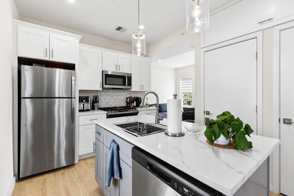 7 Transit Street, Unit 1 Boston, MA 02127 - Photo 3 of 10 a kitchen with appliances a counter space and a refrigerator