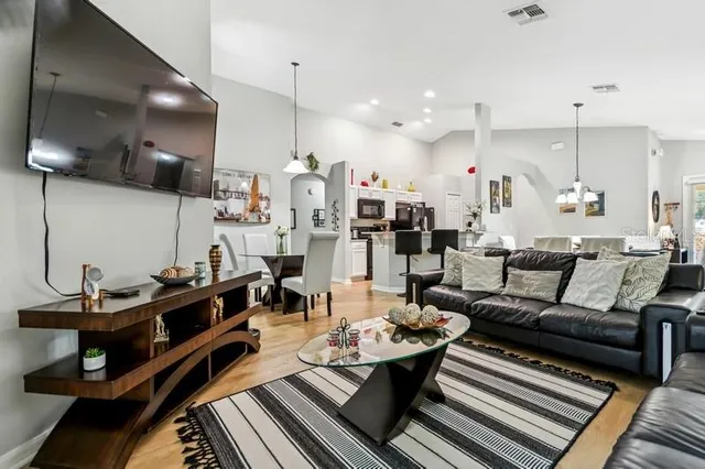 a living room with lots of furniture and kitchen view