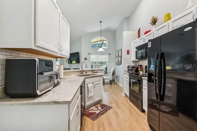 a kitchen with stainless steel appliances granite countertop a sink a stove and a refrigerator