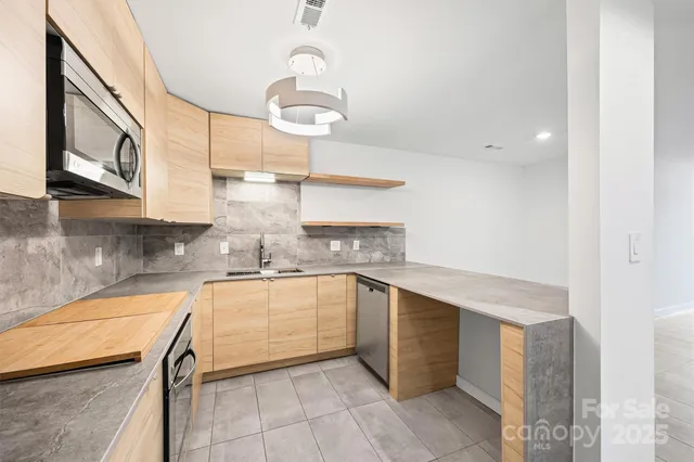 a kitchen with stainless steel appliances granite countertop a sink and cabinets