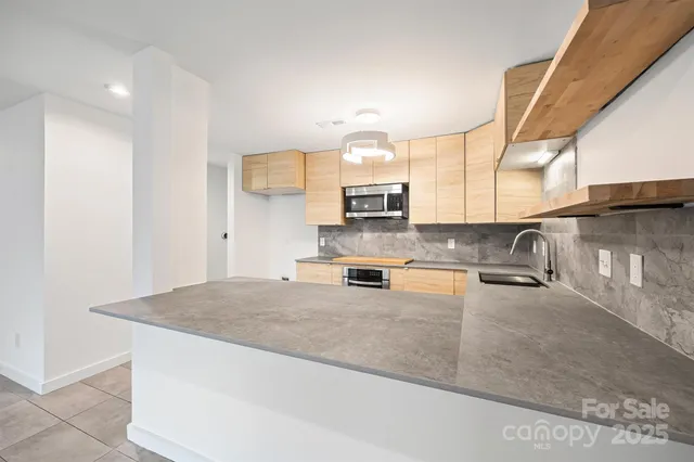 a kitchen with stainless steel appliances granite countertop a sink a stove counter space and cabinets
