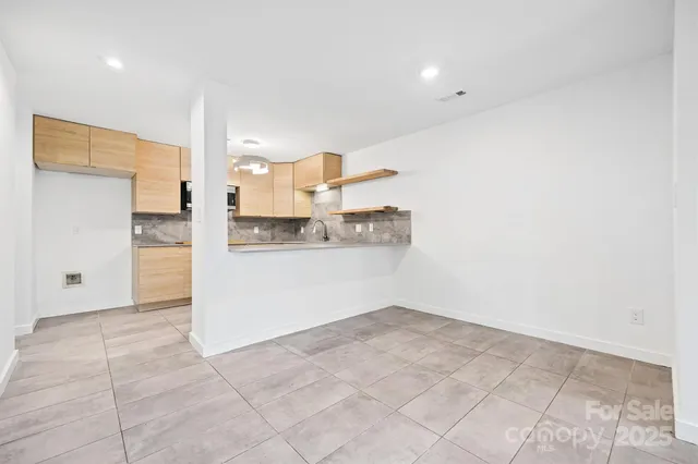 a view of a kitchen with furniture and an empty room