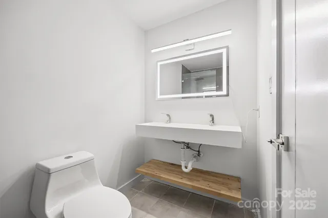 a bathroom with a toilet a sink and mirror