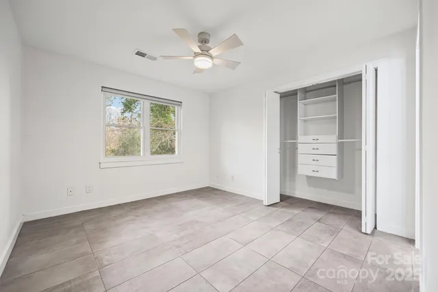 an empty room with fan and windows