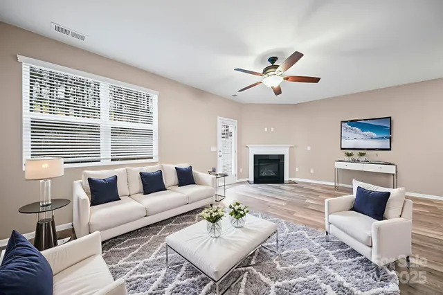 a living room with furniture a fireplace and a flat screen tv