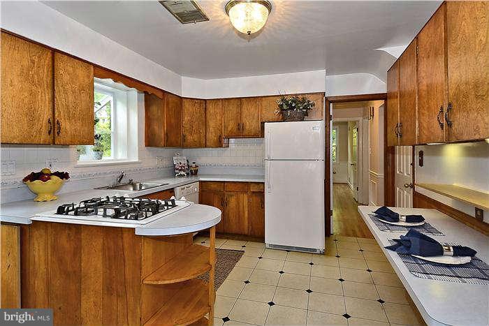 3216 Park View Road Chevy Chase, MD 20815 - Photo 9 of 29 a kitchen with a refrigerator a stove a sink and a cabinets