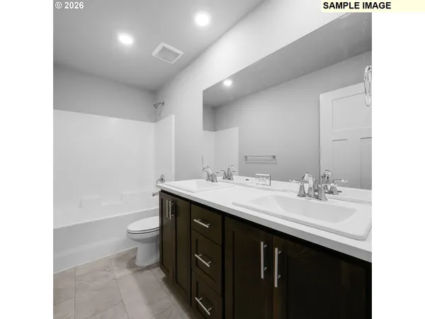 a bathroom with a double vanity sink toilet and a mirror
