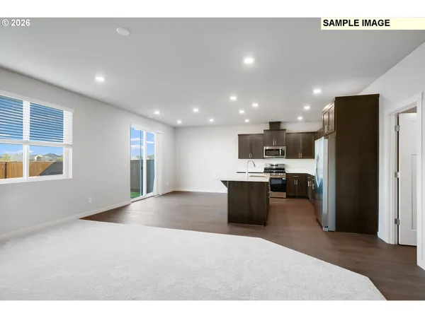 a view of kitchen with stainless steel appliances kitchen island a sink a stove a refrigerator cabinets and a window