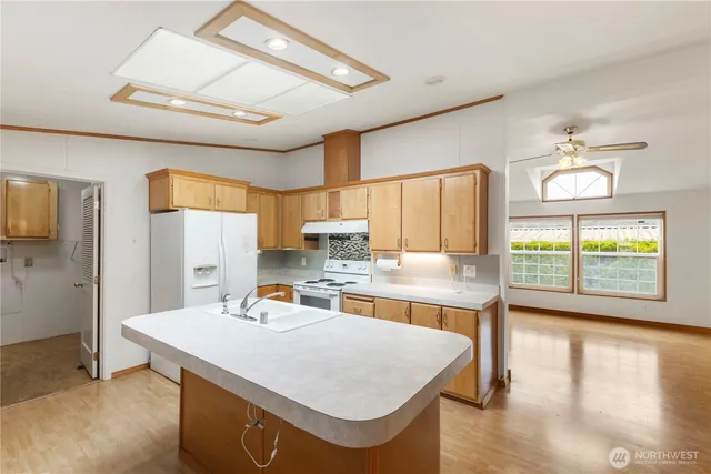 a kitchen with a stove a refrigerator a sink dishwasher with a dining table and chairs with wooden floor