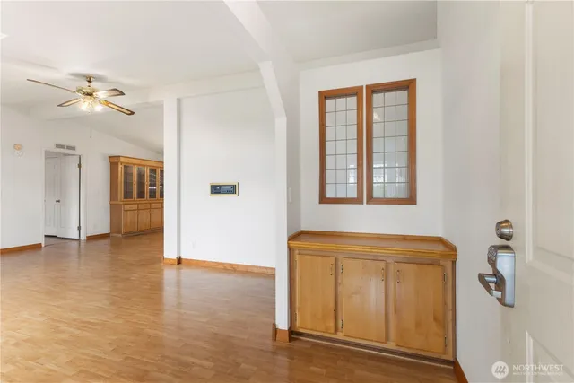 a view of a room with a ceiling fan and wooden floor
