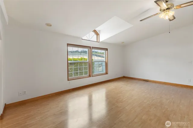 an empty room with windows and fan