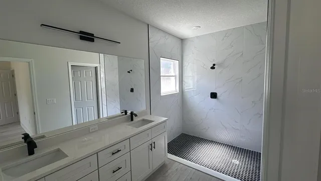 a bathroom with a shower sink and mirror