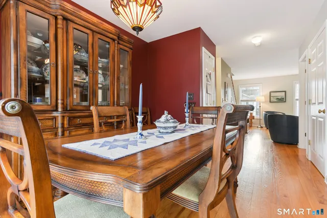 a dining hall with stainless steel appliances kitchen island granite countertop a table chairs and a refrigerator