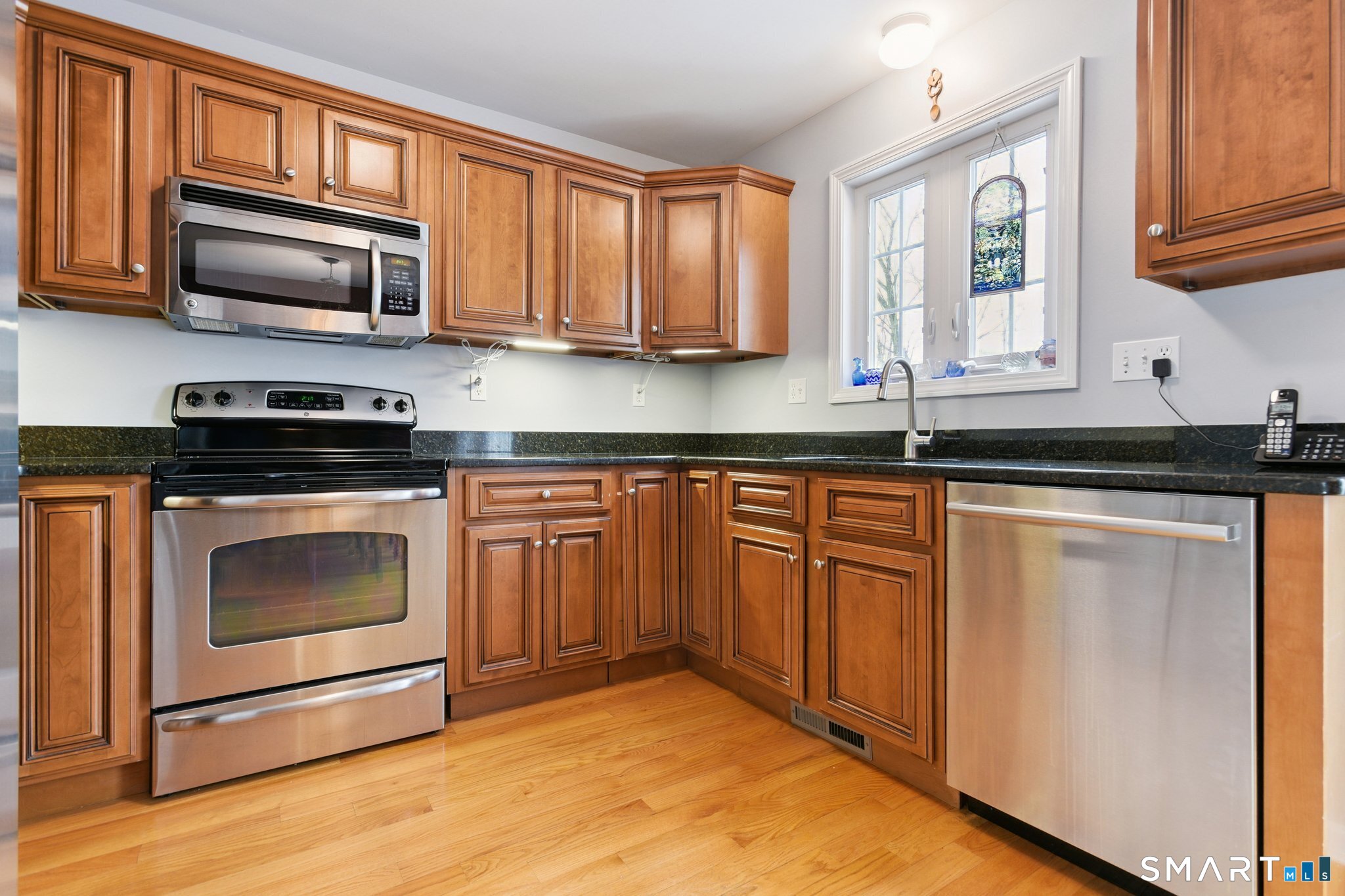 2 Bull Avenue, Unit A3 Wallingford, CT 06492 - Photo 10 of 23 a kitchen with granite countertop a stove sink and microwave