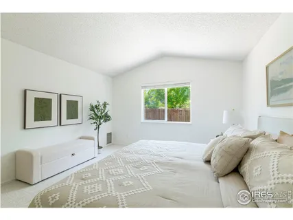 a bedroom with a large bed and a window