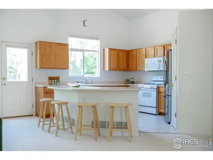 a kitchen with kitchen island granite countertop a sink cabinets and window