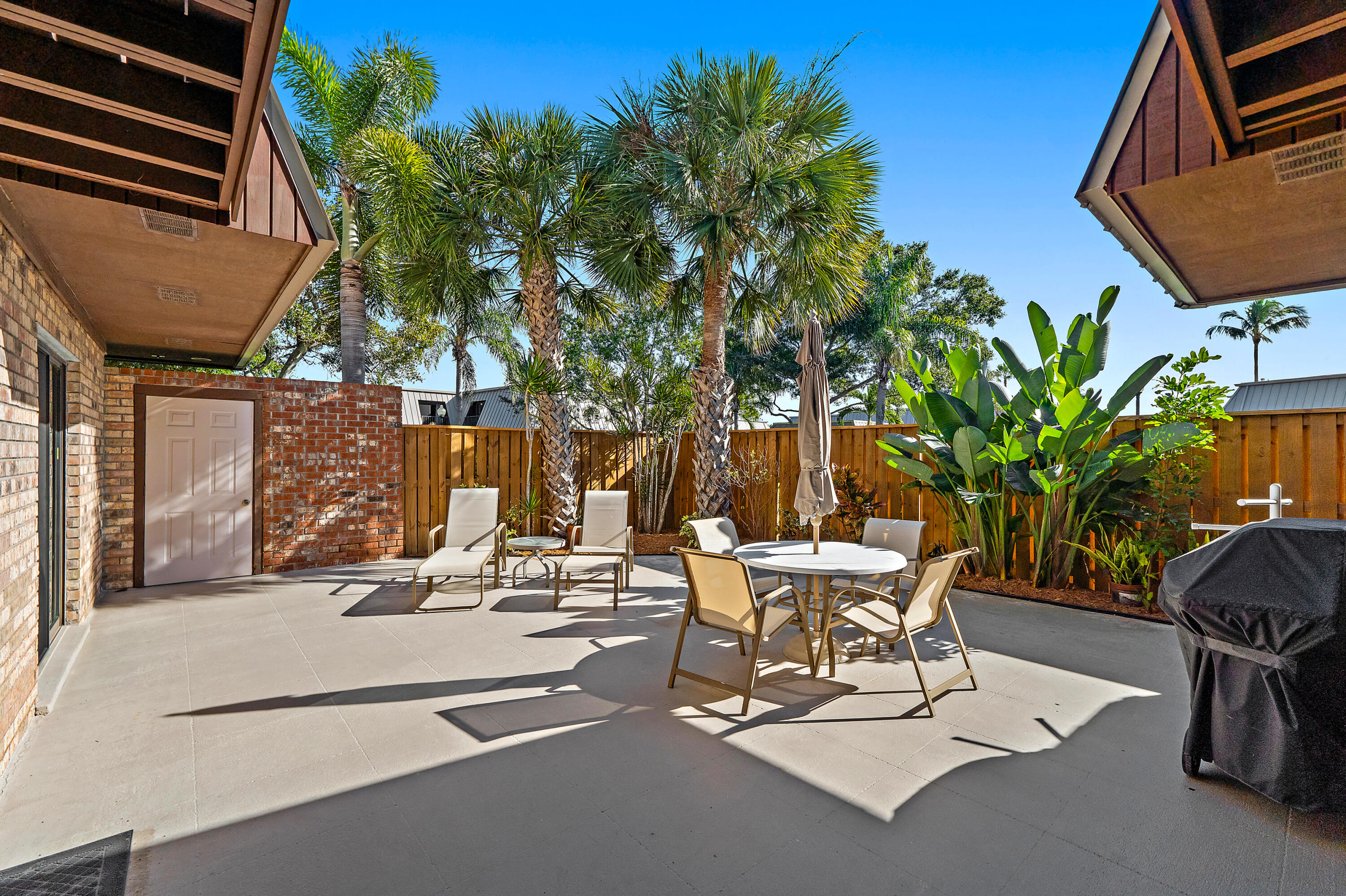 1420 Ocean Way, Unit 28D Jupiter, FL 33477 - Photo 5 of 33 a view of a patio with table and chairs and potted plants