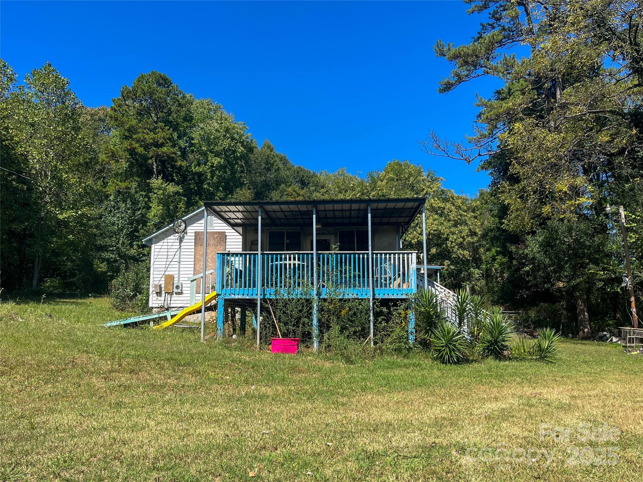 a view of a house with a backyard and a tree