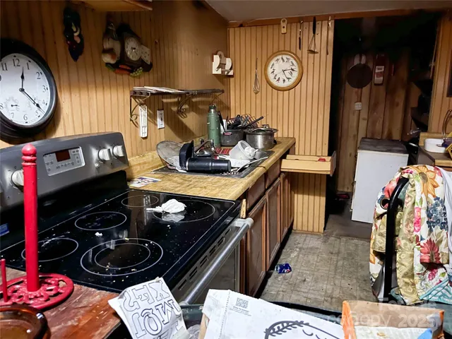 a kitchen with a stove and a clock on wall