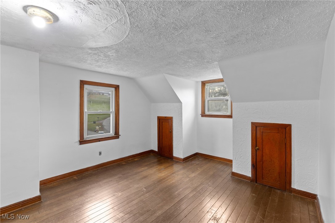 102 Potrock Road Wellsburg, WV 26070 - Photo 23 of 42 Additional living space with dark wood finished floors and a textured ceiling