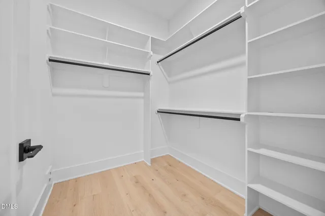 a view of walk in closet with empty racks