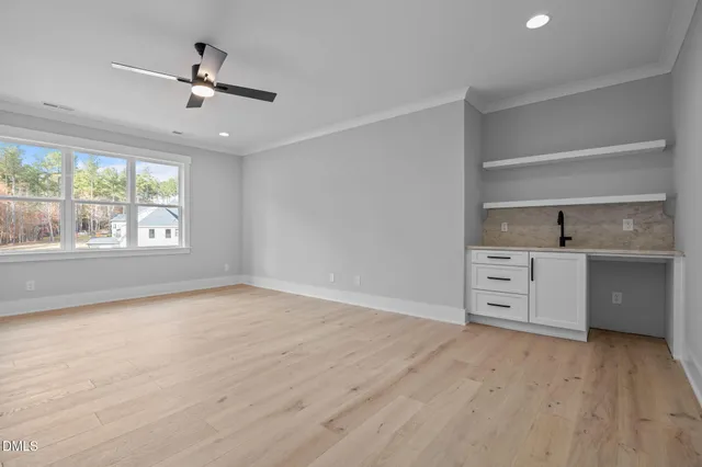 a kitchen with granite countertop a sink cabinets and a wooden floor