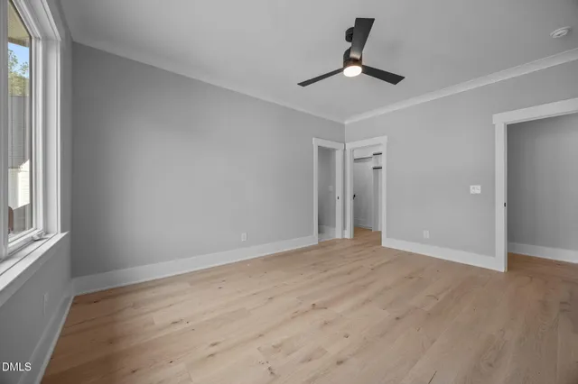 a view of an empty room with a fireplace and a window