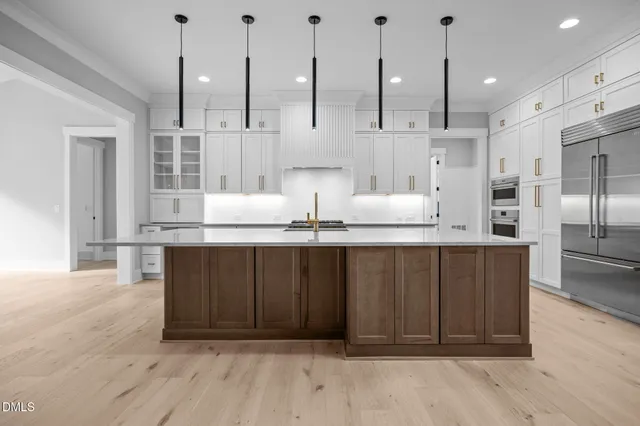 a large kitchen with stainless steel appliances kitchen island granite countertop a large counter top and a stove