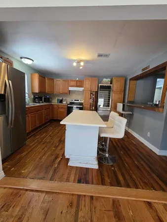 a kitchen with a table chairs refrigerator and microwave