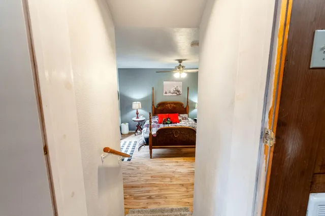 a bedroom with a bed and wooden floor