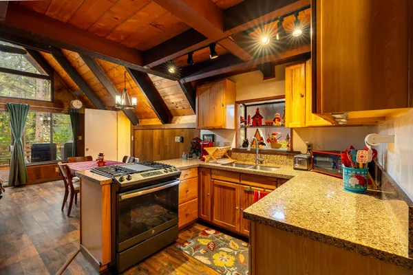 a kitchen with stainless steel appliances granite countertop a stove a sink and a microwave