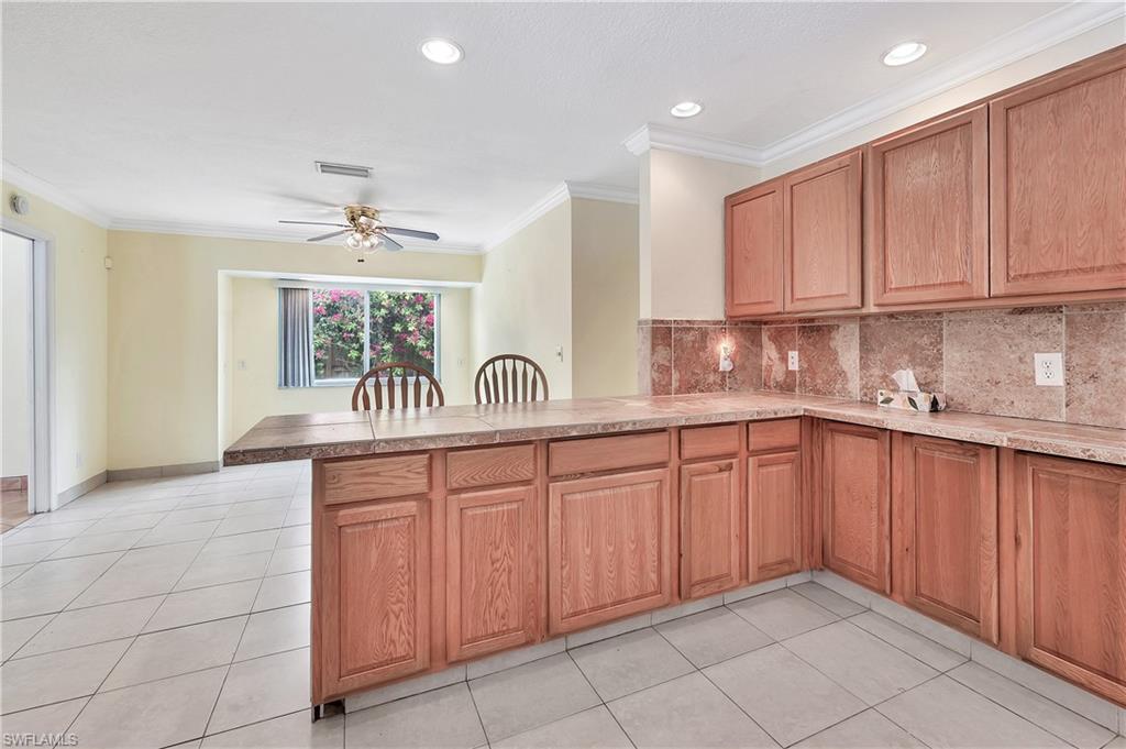 639 Pompano Drive Naples, FL 34110 - Photo 11 of 39 a kitchen with stainless steel appliances granite countertop a sink and cabinets